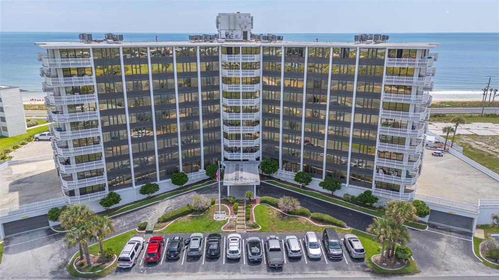 An aerial view of a multi-story beachfront condominium building with a parking lot in front — 3580 S OCEAN SHORE BOULEVARD UNIT 404, FLAGLER BEACH, FL