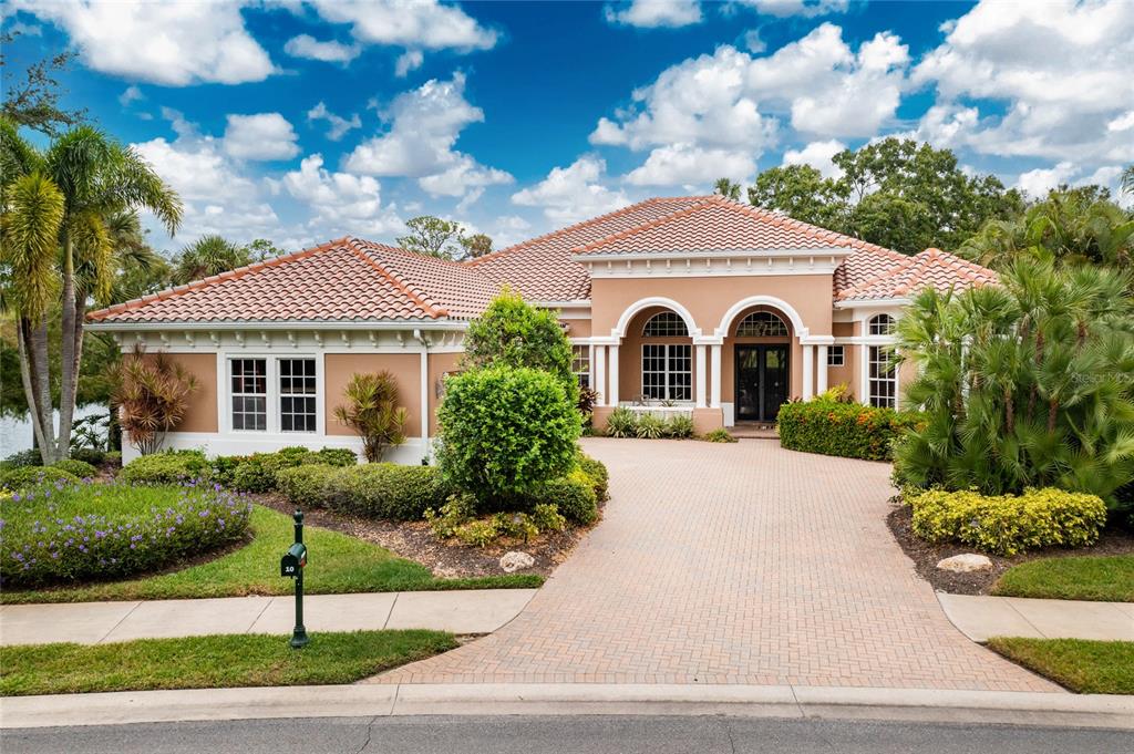 A single-story stucco house with a tiled roof and a brick paver driveway — 10 BOCA ROYALE BLVD BOULEVARD, ENGLEWOOD, FL