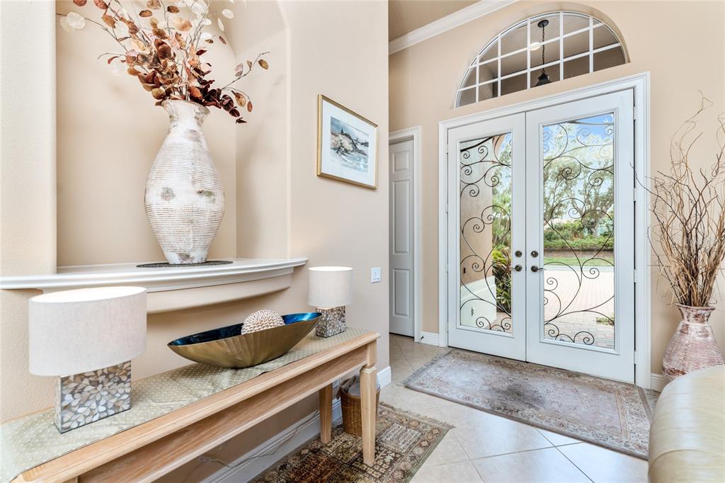 A bright entryway features a console table, a decorative wall niche, and double glass doors — 10 BOCA ROYALE BLVD BOULEVARD, ENGLEWOOD, FL