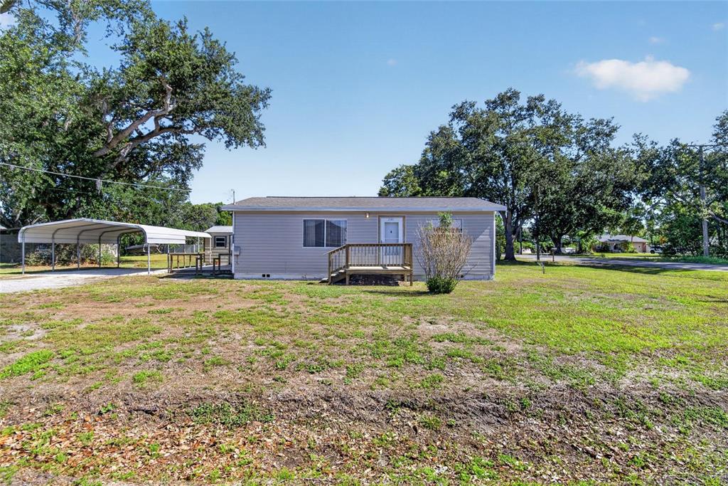 A single-story house with light siding, a front deck, and a metal carport — 2102 COLUMBUS DRIVE, BRANDON, FL