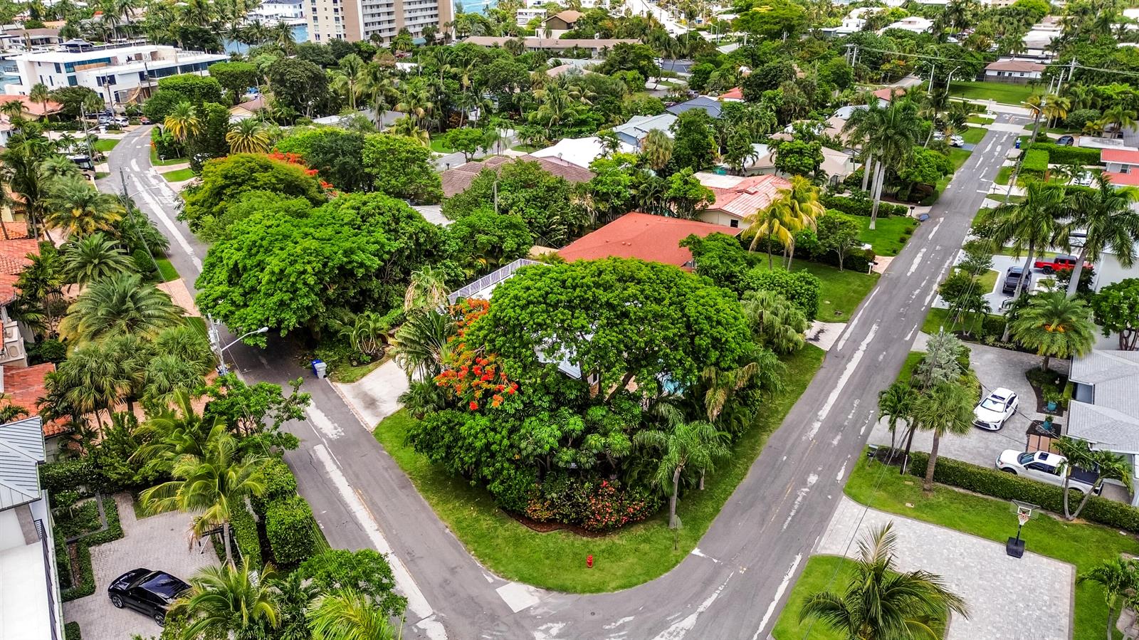 An aerial view shows a residential neighborhood with lush trees, paved streets, and houses — 2400 N Riverside Drive, Pompano Beach FL 33062, POMPANO BEACH, FL