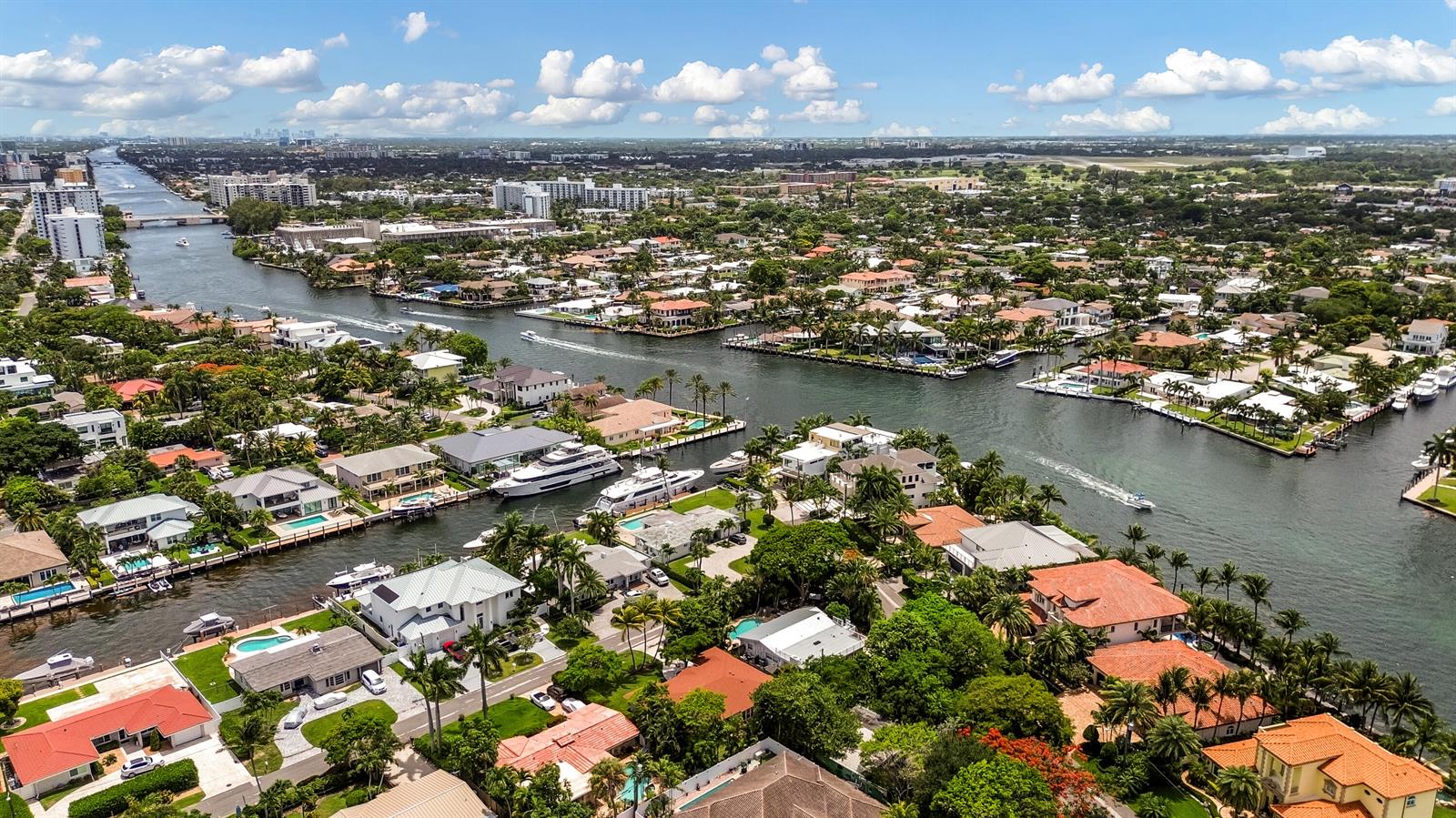 An aerial view shows waterfront homes along a canal with docked yachts and lush landscaping — 2400 N Riverside Drive, Pompano Beach FL 33062, POMPANO BEACH, FL