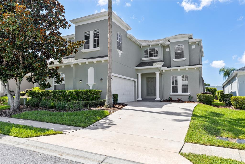 A two-story house with a gray exterior, a white garage door, and a concrete driveway — 526 PINELOCH DRIVE, HAINES CITY, FL