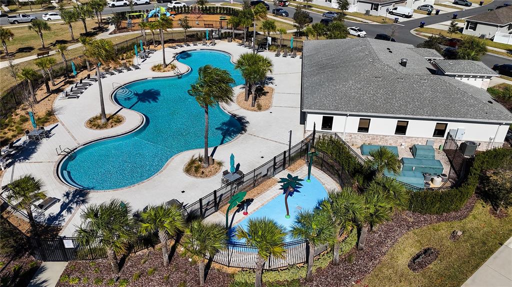 An aerial view shows a community swimming pool, a splash pad, and a clubhouse building — 10043 SEQUEL ALLEY, WINTER GARDEN, FL