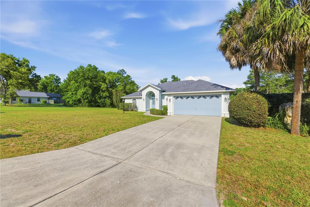 A single-story house with a light blue garage door and a concrete driveway — 10772 SW 53RD CIRCLE, OCALA, FL