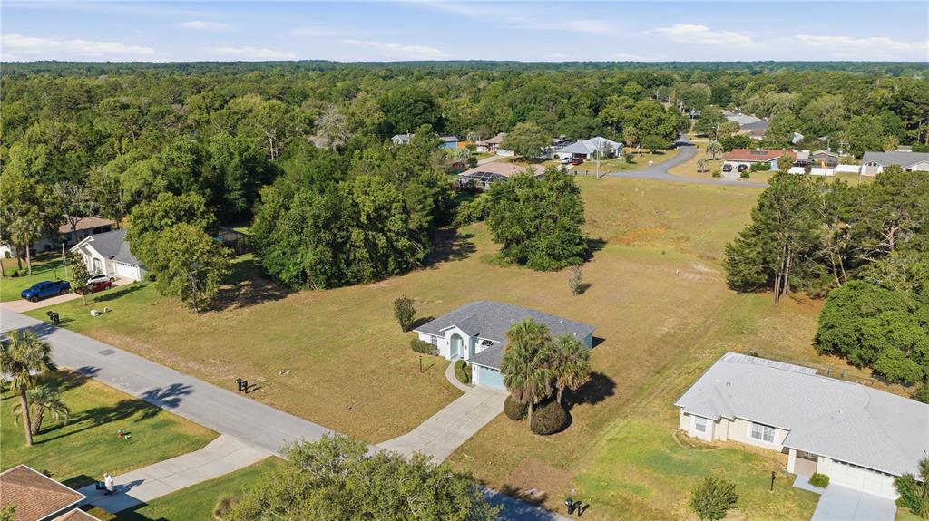 An aerial view shows a single-story house with a driveway situated on a large lot — 10772 SW 53RD CIRCLE, OCALA, FL
