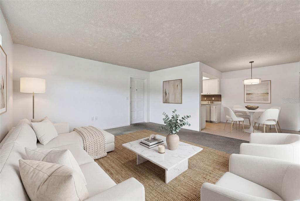 A living room and dining area feature white walls, neutral furniture, and a jute rug — 5800 HOLLYWOOD BOULEVARD UNIT 112, SARASOTA, FL