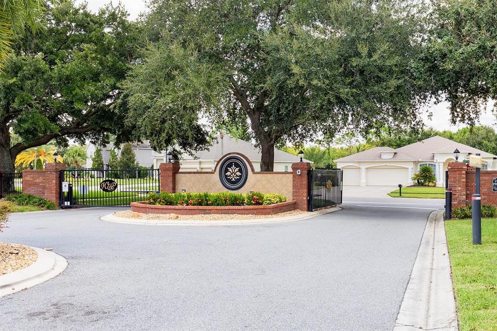 The gated entrance to a residential community features brick pillars and a central decorative sign — 2413 PRAIRIE VIEW, WINTER GARDEN, FL