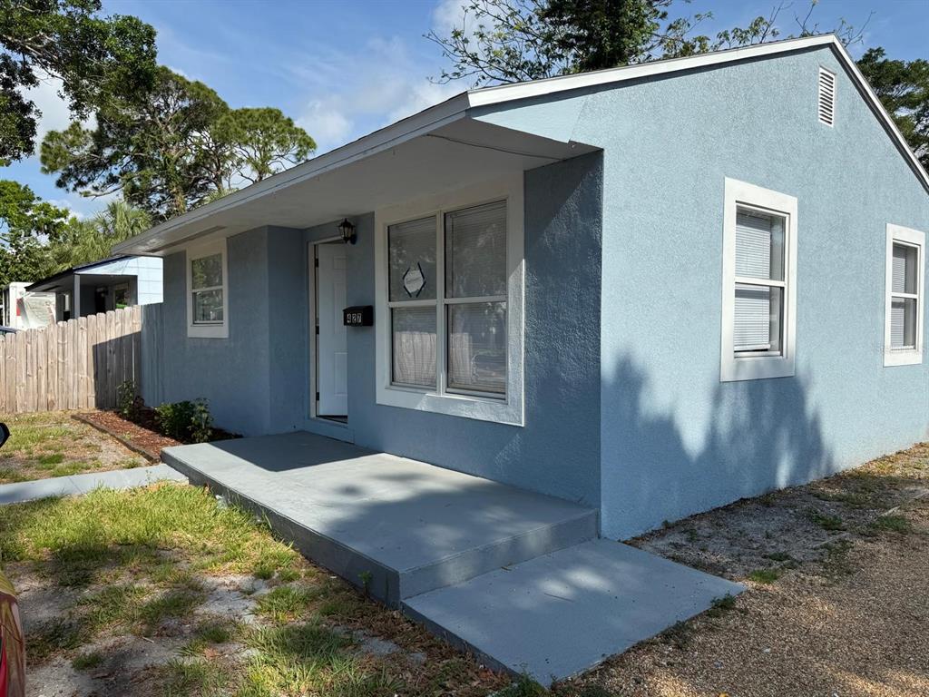 A light blue, single-story house with a concrete porch and white window trim — 427 40TH AVENUE S, ST PETERSBURG, FL