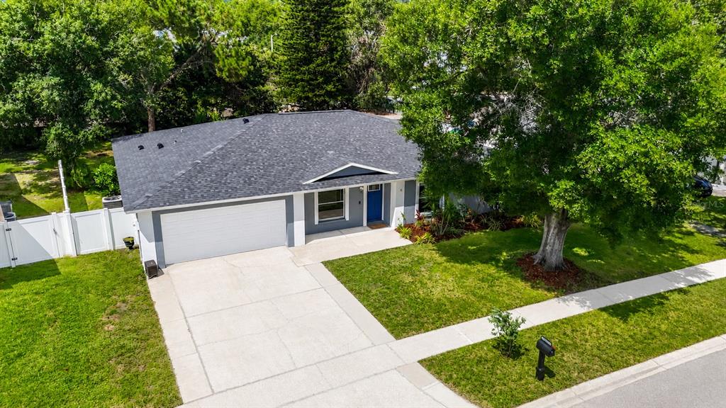 An aerial view of a single-story house with a gray roof, white garage, and blue door — 4113 HOLLOW HILL DR, TAMPA, FL
