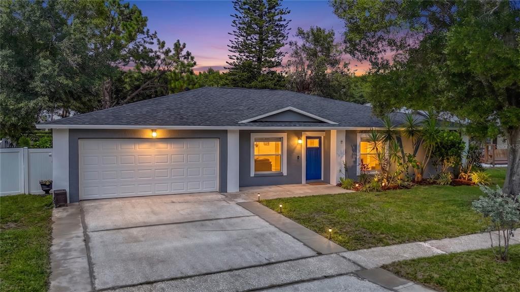 A single-story house with a gray exterior, white garage door, and a blue front door — 4113 HOLLOW HILL DR, TAMPA, FL