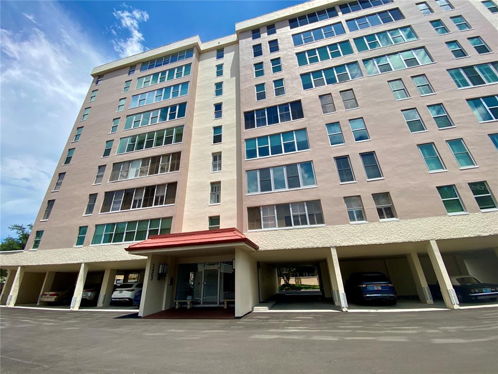 A multi-story apartment building with a covered ground-level parking area and a red roof — 2403 S ARDSON PLACE UNIT 402B, TAMPA, FL