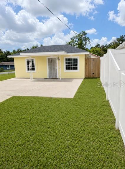 A yellow single-story house with a concrete driveway and a white vinyl fence — 1807 E WATERS AVENUE, TAMPA, FL