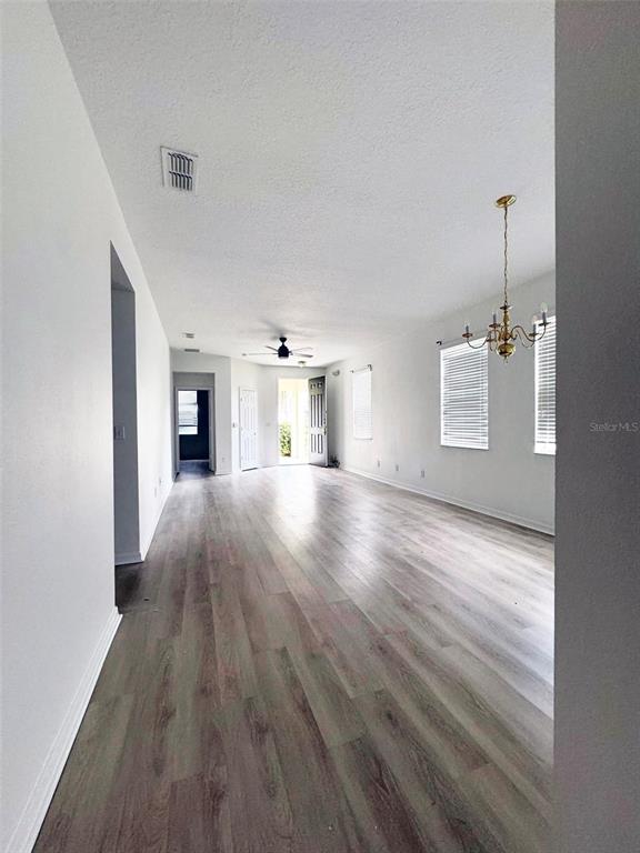 An empty room with light wood-look flooring, white walls, and a ceiling fan — 654 KETTERING ROAD, DAVENPORT, FL