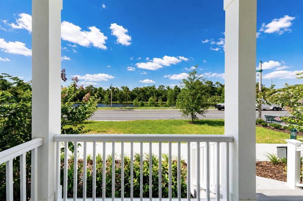 A view from a white-railed porch looking out toward a road, trees, and a pond — 2408 CELEBRATION BOULEVARD, KISSIMMEE, FL