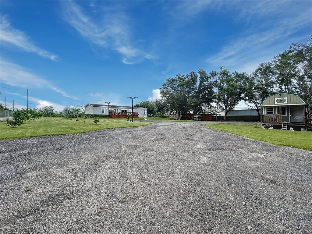 A gravel driveway leads to a mobile home and a small shed on a grassy lot — 3710 KANDY LANE, HAINES CITY, FL