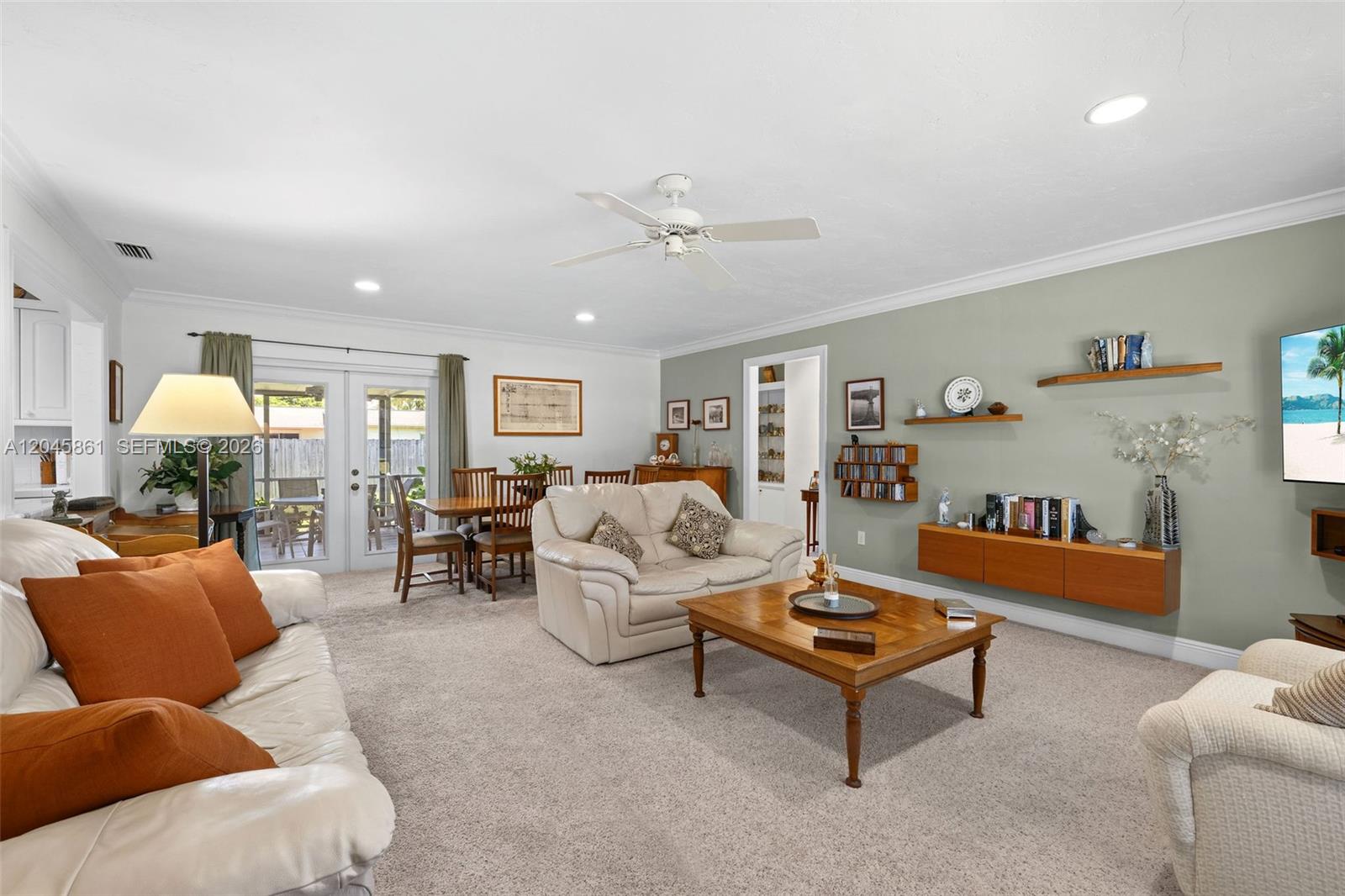 A living room features beige carpet, a white ceiling fan, and a wall-mounted wooden cabinet — 9971 SW 156th Ter, Miami FL 33157, MIAMI, FL