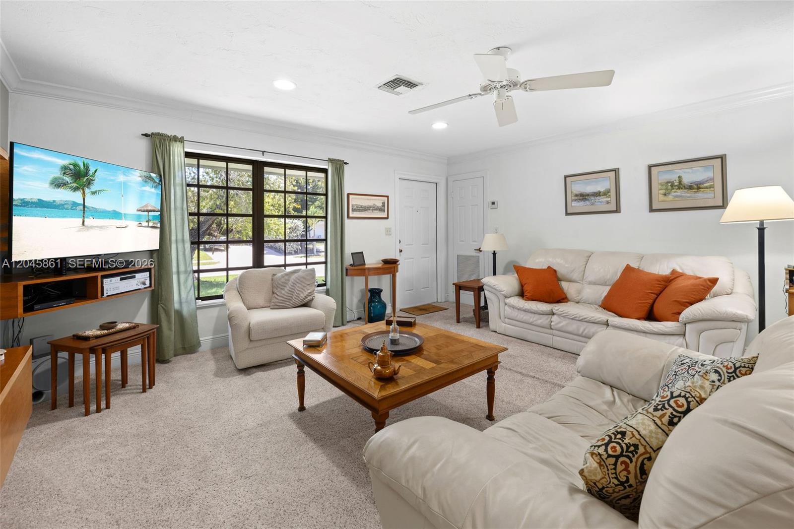 A living room features white walls, carpeted floors, a ceiling fan, and white leather sofas — 9971 SW 156th Ter, Miami FL 33157, MIAMI, FL