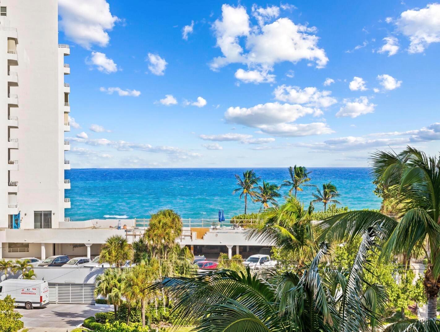An exterior view of a white high-rise building overlooking the ocean and palm trees — 3450 S Ocean Boulevard # 505, Highland Beach FL 33487, HIGHLAND BEACH, FL
