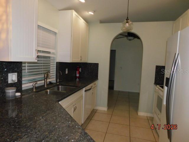 A kitchen features white cabinets, dark granite countertops, a double sink, and tiled flooring — 1625 SW 43RD STREET, CAPE CORAL, FL