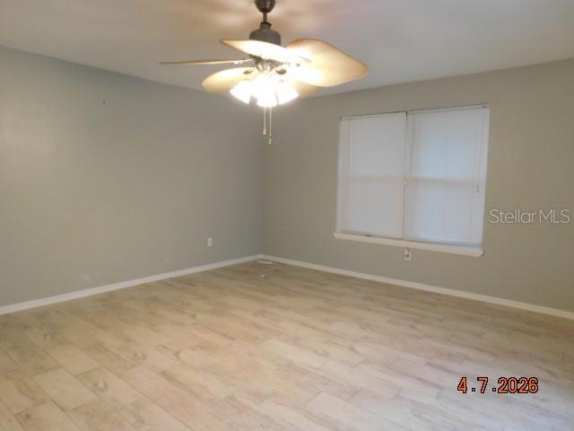 An empty room features light-colored wood-look tile flooring, a ceiling fan, and a window — 1625 SW 43RD STREET, CAPE CORAL, FL