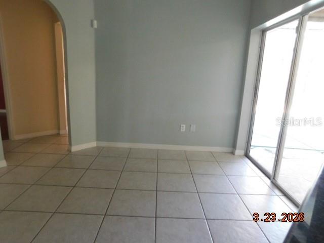 A room with light-colored tile flooring, pale blue walls, and a sliding glass door — 1625 SW 43RD STREET, CAPE CORAL, FL