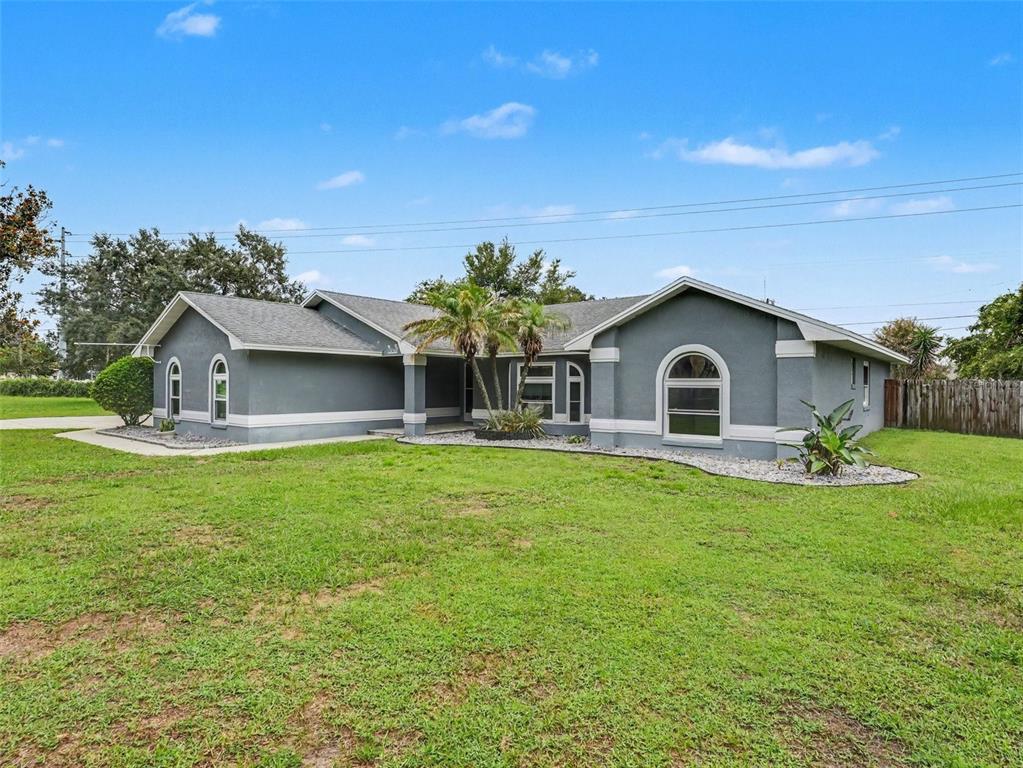 A single-story gray house with a shingled roof and a large front lawn — 6736 NELLS WAY, LAKELAND, FL