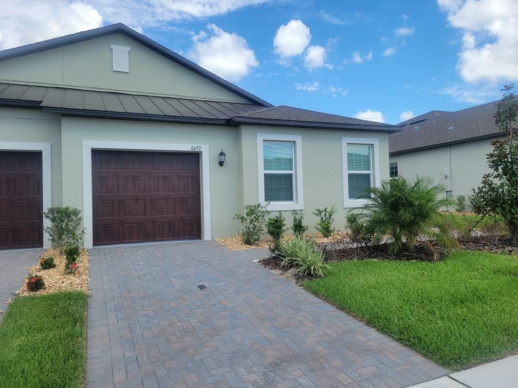 A light green single-story house with a brown garage door and a paved driveway — 6692 HOMEBOUND WAY, NEW PORT RICHEY, FL