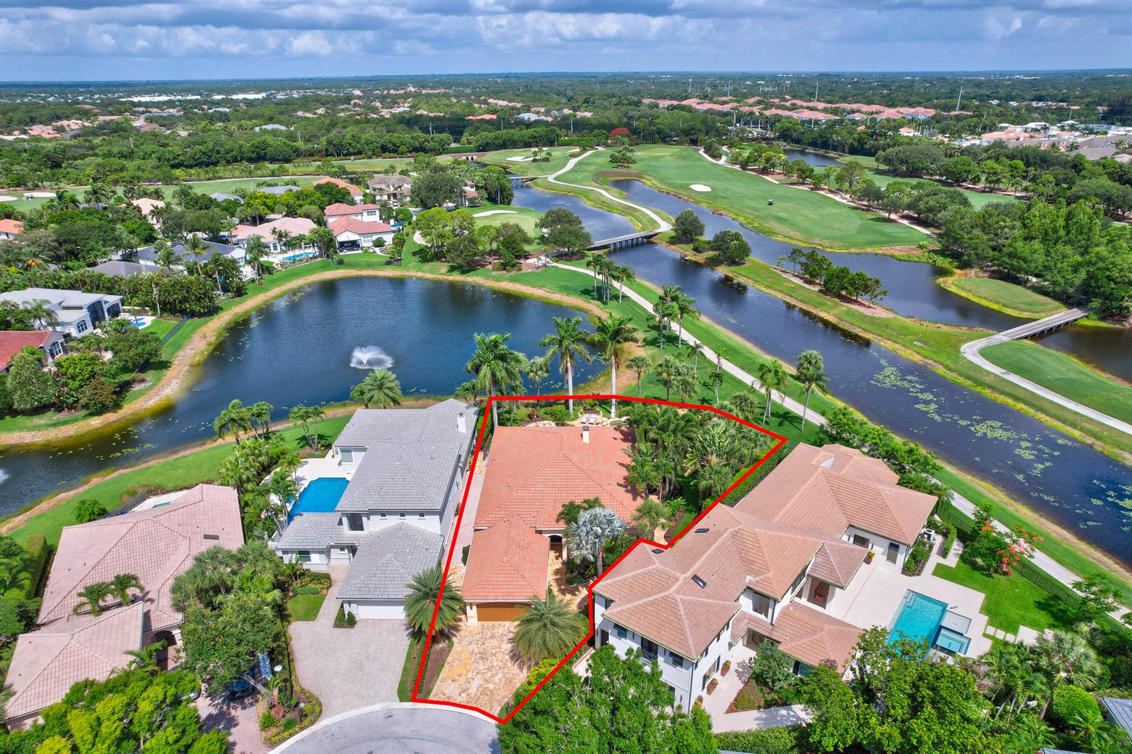 An aerial view shows a house with a red tile roof situated between two properties — 186 Golf Village Boulevard, Jupiter FL 33458, JUPITER, FL