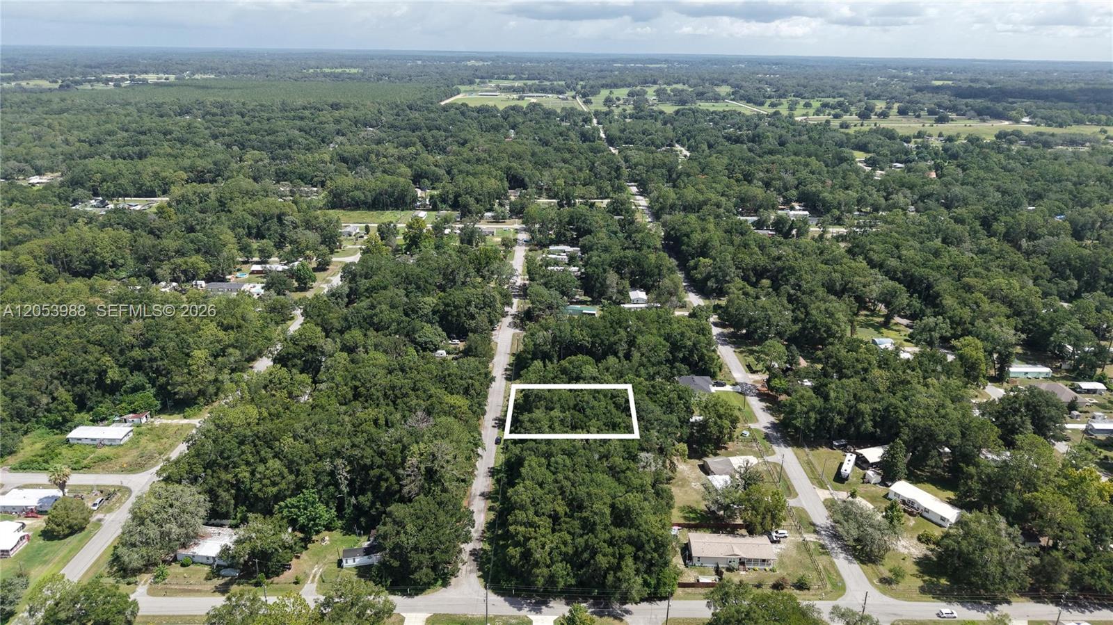 An aerial view shows a rectangular plot of land outlined in white amidst dense trees — 0 NW 113th Ave, Ocala FL 34482, OCALA, FL