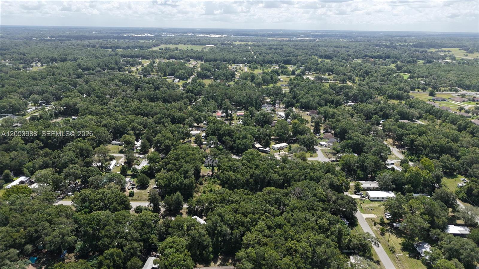 An aerial view shows a rural residential area with scattered houses nestled among dense trees — 0 NW 113th Ave, Ocala FL 34482, OCALA, FL