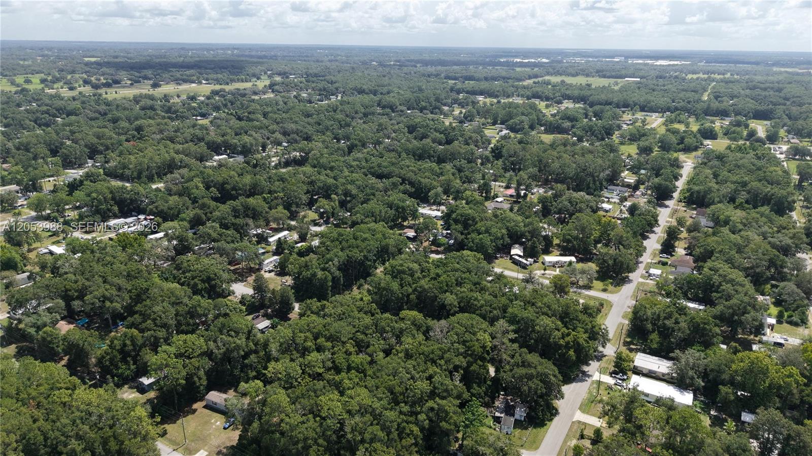 An aerial view shows a rural residential area with scattered houses nestled among dense trees — 0 NW 113th Ave, Ocala FL 34482, OCALA, FL