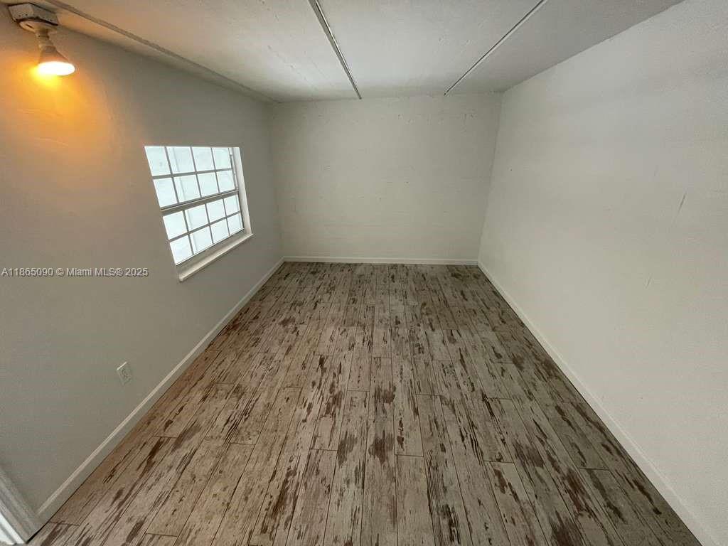 An empty room features white walls, a single window, and light-colored wood-look tile flooring — 1771 Blount Rd # 204, Pompano Beach FL 33069, POMPANO BEACH, FL