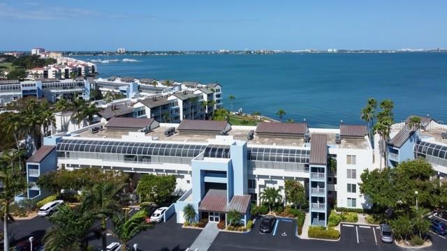 An aerial view shows a multi-story waterfront apartment complex with a parking lot below — 5155 ISLA KEY BOULEVARD S UNIT 301, ST PETERSBURG, FL