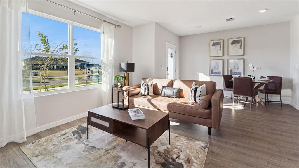 A living room features a brown leather sofa, a coffee table, and a dining area — 280 PRESTON COVE DRIVE, ST CLOUD, FL