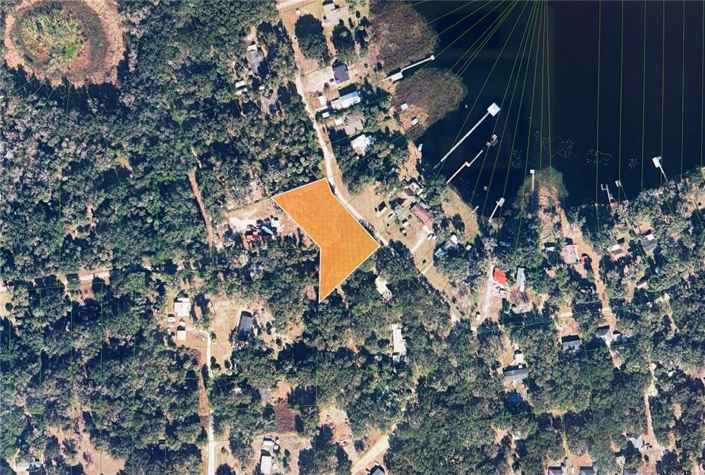 An aerial view shows a highlighted vacant lot surrounded by trees near a lake — 161 LITTLE ORANGE LAKE DRIVE, HAWTHORNE, FL