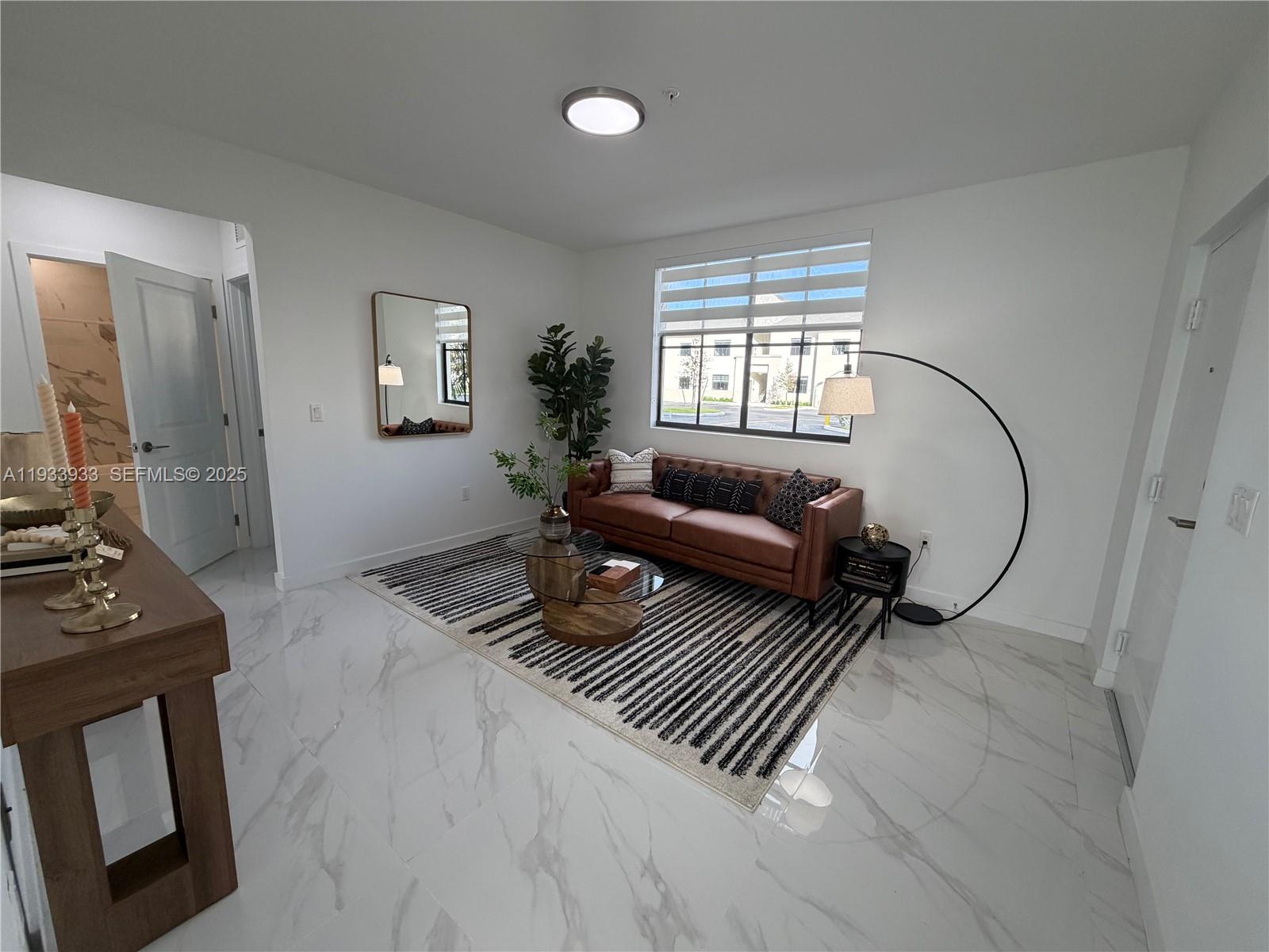 A living room features a brown leather sofa, a striped rug, and white marble floors — 2308 E 4th ave # 208, Hialeah FL 33013, HIALEAH, FL