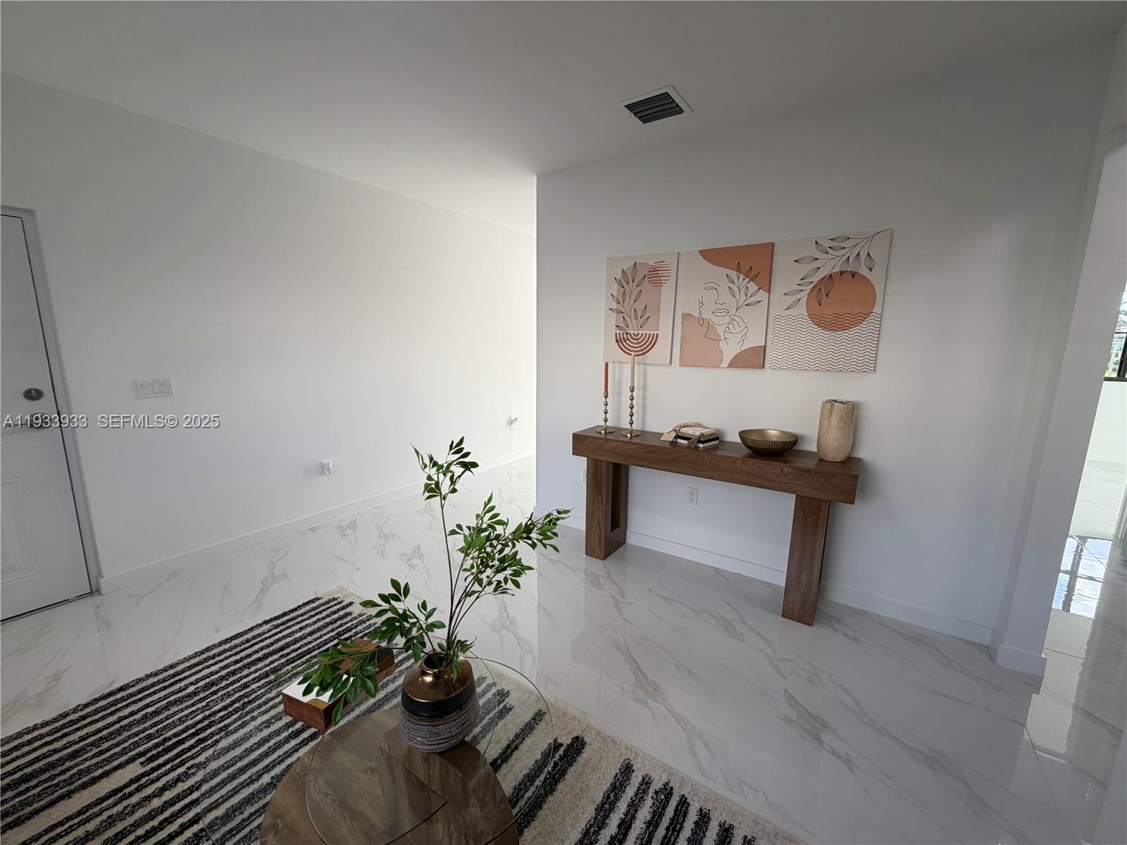 A bright room features white marble floors, a wooden console table, and abstract wall art — 2308 E 4th ave # 208, Hialeah FL 33013, HIALEAH, FL