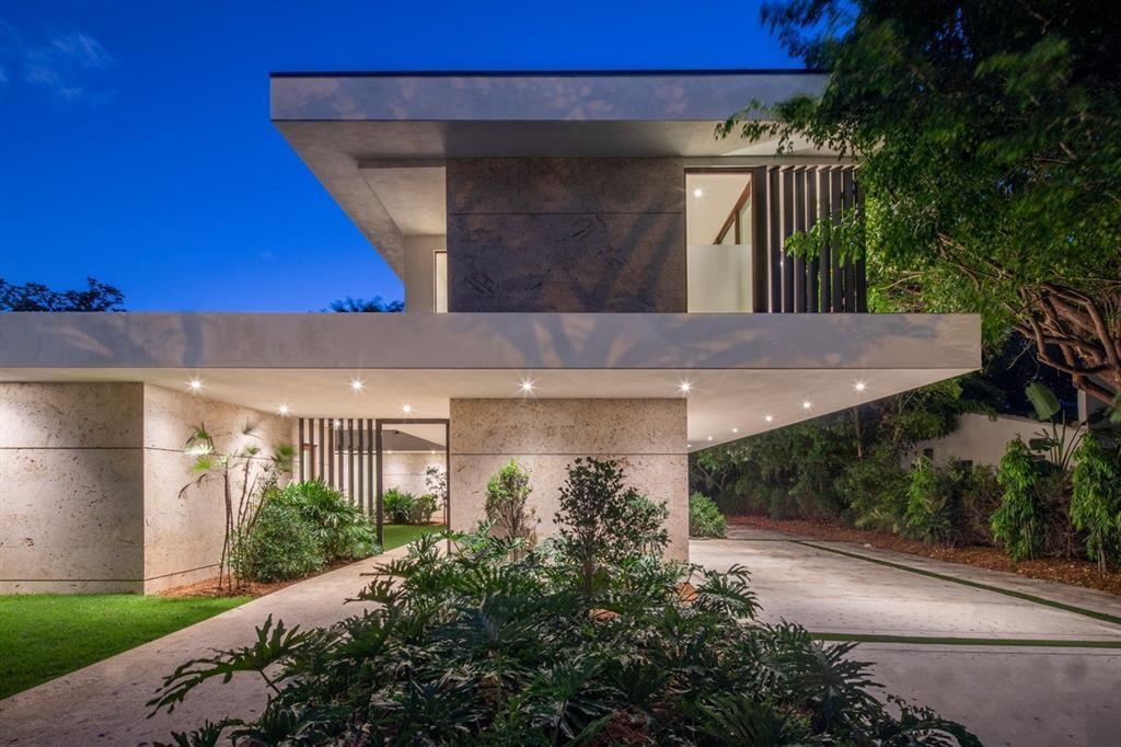 A modern two-story house with stone cladding, recessed lighting, and a paved driveway at dusk — 5831 SW 37th Terrace, Dania Beach FL 33312, DANIA BEACH, FL