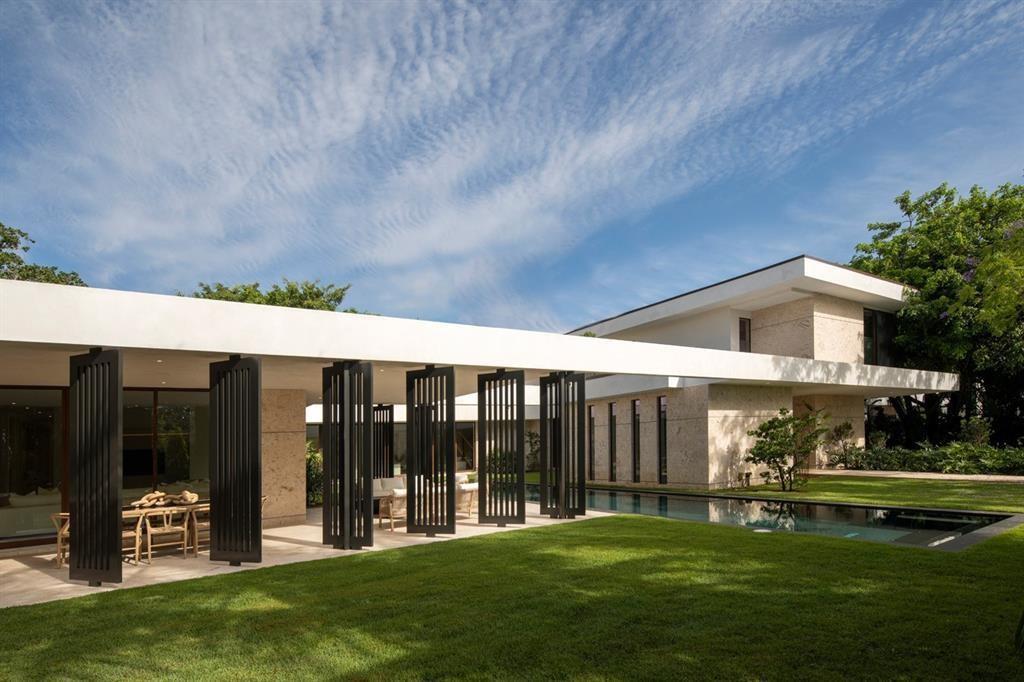 A modern house with a flat roof, stone walls, and black louvered shutters by a pool — 5831 SW 37th Terrace, Dania Beach FL 33312, DANIA BEACH, FL