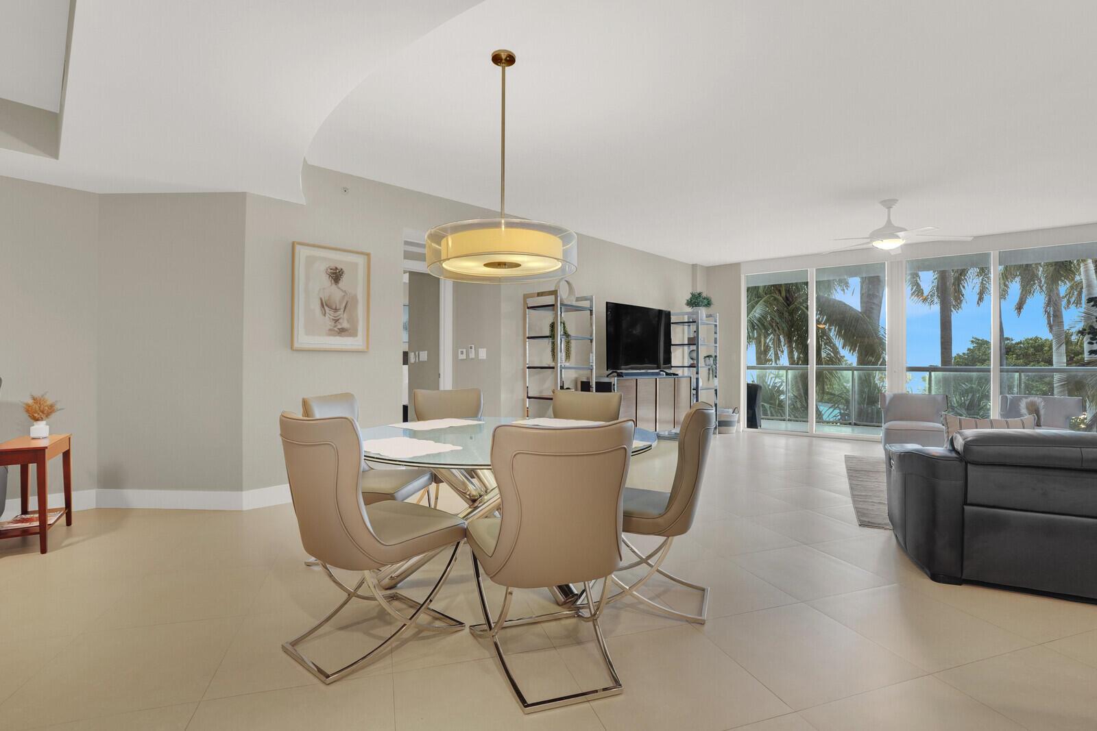 A dining area with a glass table and chairs sits before a living room with balcony views — 1 N Ocean Boulevard # 508, Pompano Beach FL 33062, POMPANO BEACH, FL