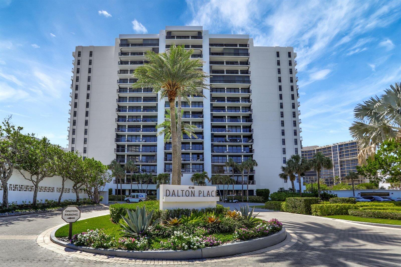 A multi-story residential building stands behind a landscaped circular driveway with a palm tree — 4748 S Ocean Boulevard # 301, Highland Beach FL 33487, HIGHLAND BEACH, FL