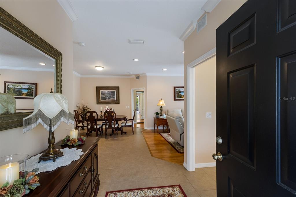 An entryway leads to a dining area and living room with tile and hardwood flooring — 915 SW BARCLAY COURT, VENICE, FL