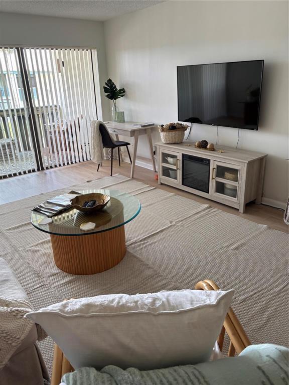 A living room features a glass-topped coffee table, a television console, and a small desk — 175 SE Saint Lucie Boulevard # C34, Stuart FL 34996, STUART, FL