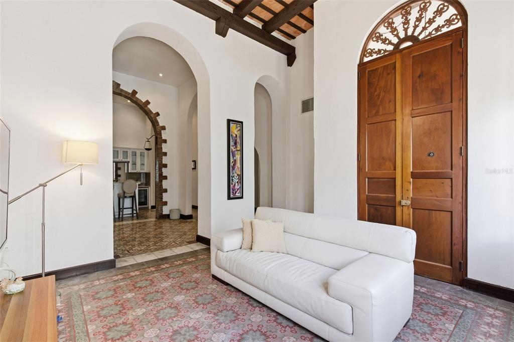 A white sofa sits on a patterned rug in a room with arched doorways — 65 CALLE SAN FRANCISCO, OLD SAN JUAN, PR