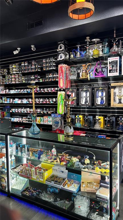 A retail store display case is filled with glass pipes and accessories beneath shelves of hookahs — 0000 WEST LINEBAUGH AVENUE, TAMPA, FL