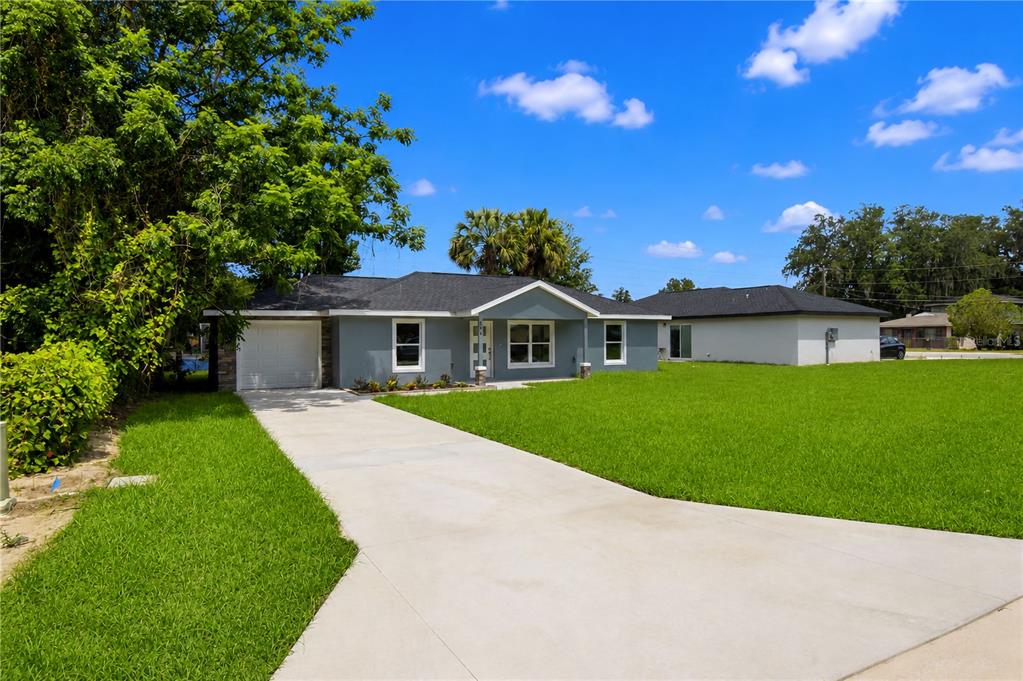 A single-story gray house with a white garage door and a concrete driveway — 510 SW 15 AVENUE, OCALA, FL