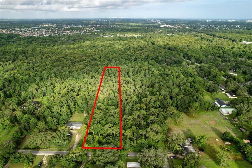 An aerial view shows a rectangular, wooded plot of land outlined in red — 848 HAMILTON DRIVE, ORLANDO, FL