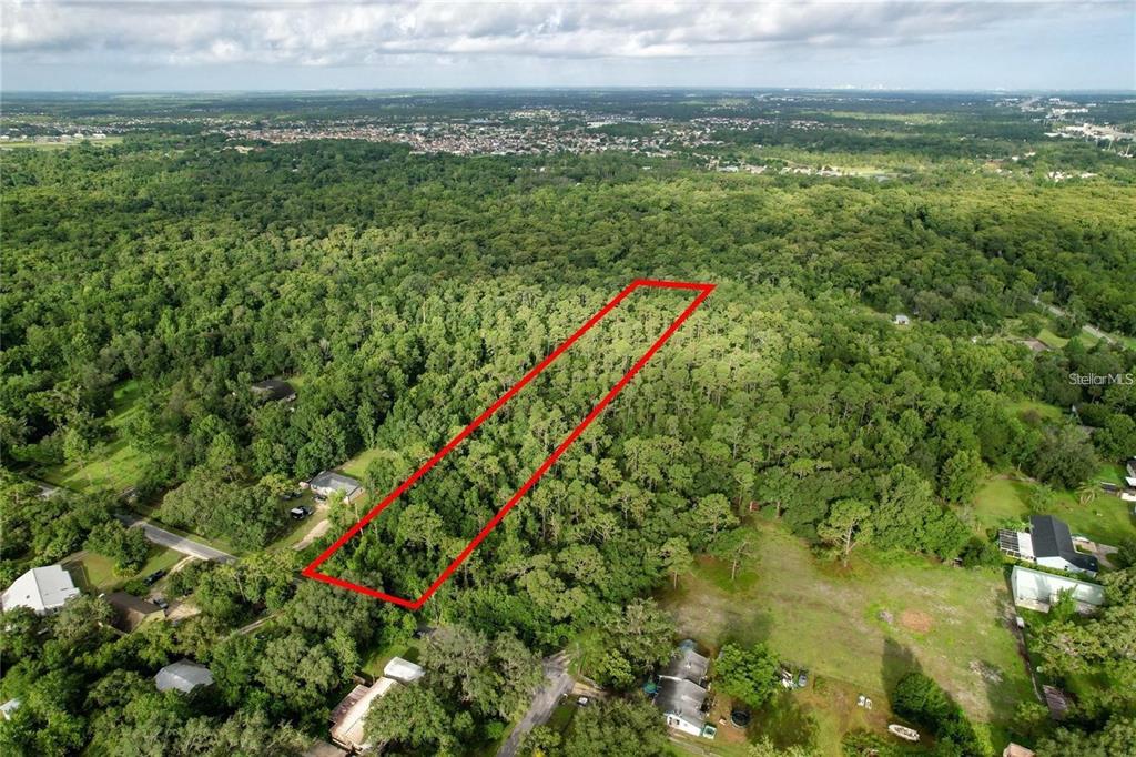 An aerial view shows a rectangular plot of land outlined in red amidst dense forest — 848 HAMILTON DRIVE, ORLANDO, FL