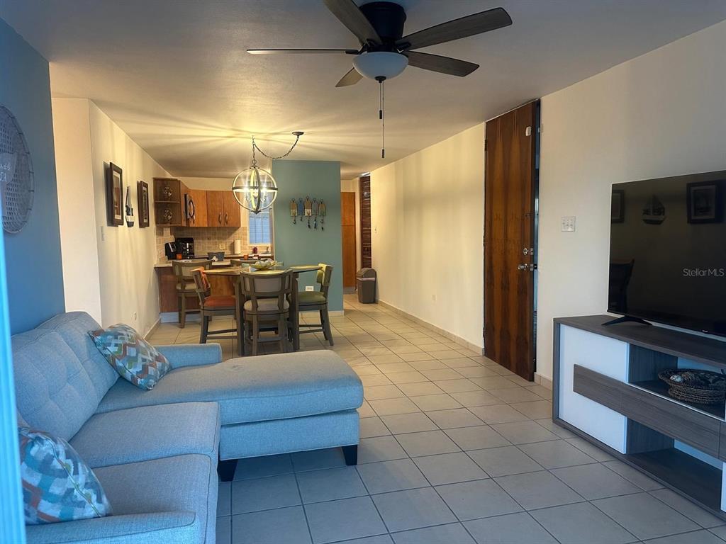 A living room with a sectional sofa, dining area, and kitchen with tile flooring — 1 SUNBAY MARINA VILLAS, FAJARDO, PR